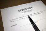 Someone filling out Severance Agreement - Severance agreement review concept