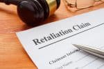 Retaliation claim lying on the desk with gavel - workplace retaliation concept